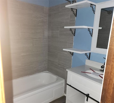 Bathroom featuring bathtub / shower combination and vanity