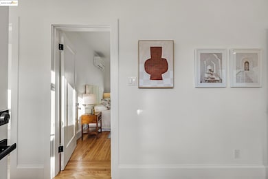 Corridor featuring light wood-style flooring and a wall mounted air conditioner