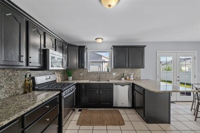 Kitchen features ceramic tile flooring, cabinets w