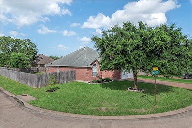 View of home's exterior with brick siding and driv