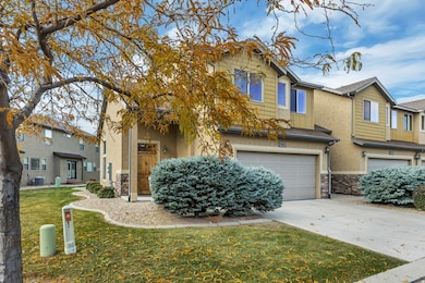 View of front of home featuring concrete driveway, stucco siding, stone siding, and a front yard