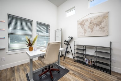 Home office with light wood finished floors and baseboards