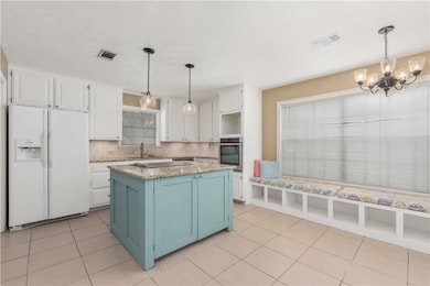 Kitchen featuring white fridge with ice dispenser,