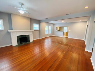 Unfurnished living room featuring dark wood finished floors, a fireplace, ceiling fan, and recessed lighting
