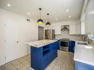 Huge island kitchen has marble and quartz counter tops, new cabinets plus high ceiling and recessed lighting.