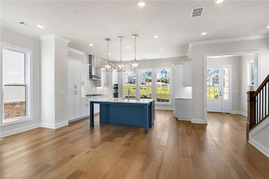 Homesite 11 will feature white cabinets at the perimeter and a Driftwood stained island and beautiful quartz countertops. True open floorplan to entertain! Photo of previously built Greenville floorplan.