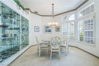 Carpeted dining space with a chandelier glass encl