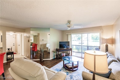 Living room featuring ceiling fan, a textured ceil