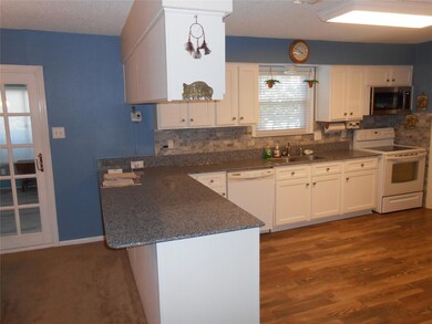 Kitchen with dark wood-type flooring, white cabine