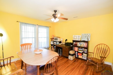 Dining area with wood finished floors, a ceiling fan, and baseboards