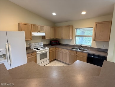 Kitchen with white appliances, a sink, under cabin