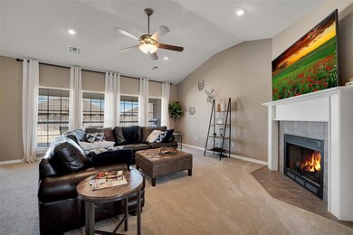 Carpeted living room featuring ceiling fan, a tile