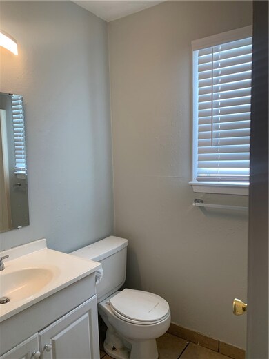 Bathroom featuring baseboards, toilet, vanity, and