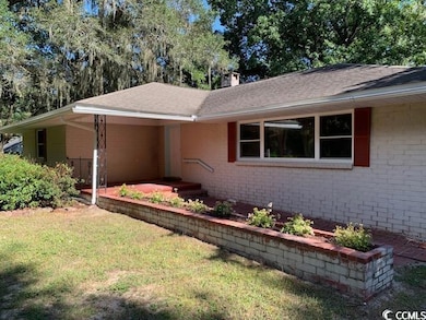Ranch-style house with brick siding, a front yard, and a chimney