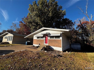 View of front facade featuring driveway, brick siding, and entry steps