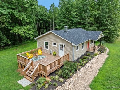 Back of house with a deck and a lawn