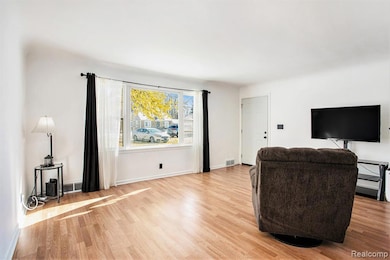 Living room featuring light wood-style flooring and baseboards