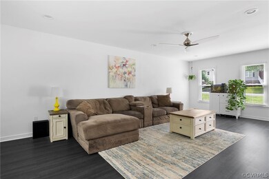 Living room featuring ceiling fan and dark wood-ty