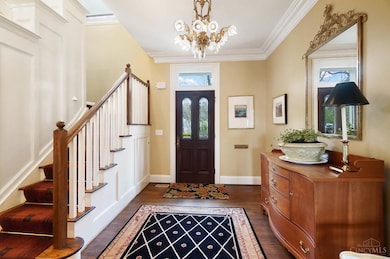 The gracious center hall entry greets you with a 10' ceiling trimmed with crown molding, an ornate historical chandelier and gleaming hardwood floors.