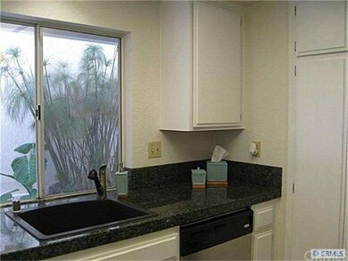 Bright kitchen with granite tile overlooks side ya