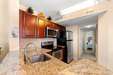Kitchen featuring light stone counters, a sink, st
