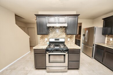 Stainless steel appliances and a natural stone bac