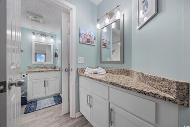Bathroom with vanity, a textured ceiling, and wood