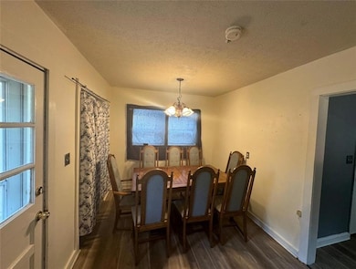 Dining area featuring a notable chandelier, a text