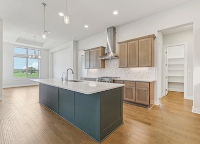 Kitchen with a tray ceiling, a chandelier, backsp