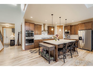 Warm wood cabinetry and sleek stainless appliances anchor this inviting, entertainer-ready kitchen space.