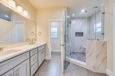 The primary bathroom offers a spa-like feel with i