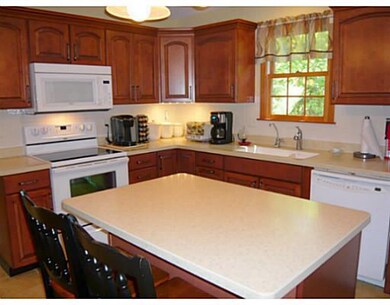 Kitchen. updated kitchen w/Corian counter tops, newer cabinets, new electric stove, center island with breakfast bar