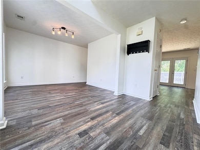 Unfurnished living room featuring a textured ceili