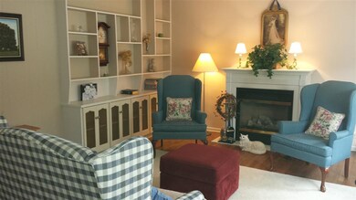 Living room has a cozy feel with a fireplace, buil