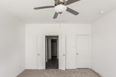 Unfurnished bedroom featuring light carpet and ceiling fan