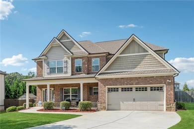 Craftsman inspired home featuring covered porch, driveway, board and batten siding, and roof with shingles