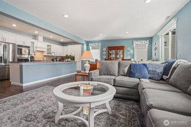 Main floor great room with a formal living room featuring a gas fireplace opens to the kitchen and dining room with sliding door to the back deck with Cascade Mountain views and southern exposure.