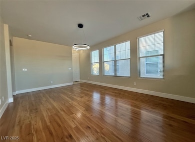 Unfurnished room featuring baseboards and dark wood-style floors