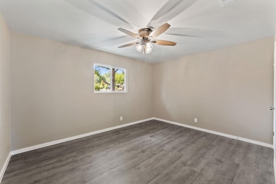 Empty room featuring dark wood-style floors and b