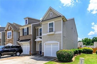 Multi unit property with driveway, board and batten siding, an attached garage, and stone siding