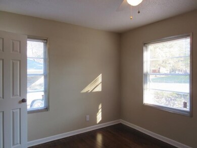 Unfurnished room with a ceiling fan, dark wood-sty