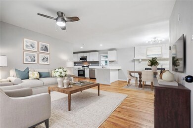 Living room with light wood finished floors, ceiling fan, and recessed lighting**Virtually Staged**