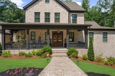 View of front of home featuring a porch, a front yard, and brick siding