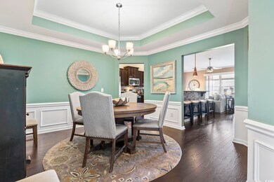 Dining area with dark wood-type flooring, a raised