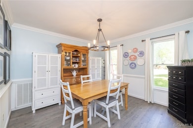 Dining space with dark wood-type flooring, crown m