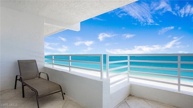Balcony featuring view of water and beach
