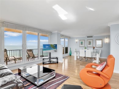 Living room with ornamental molding, baseboards, wood finished floors, and a water view