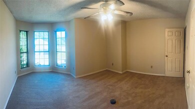Empty room featuring ceiling fan, and a textured c