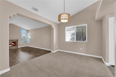 Unfurnished living room with lofted ceiling, carpet floors, and a fireplace