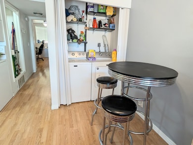 Dining room with light wood-type flooring, ceiling fan, and separate washer and dryer